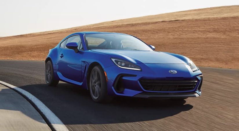 A blue 2023 Subaru BRZ Limited is shown rounding a race track.