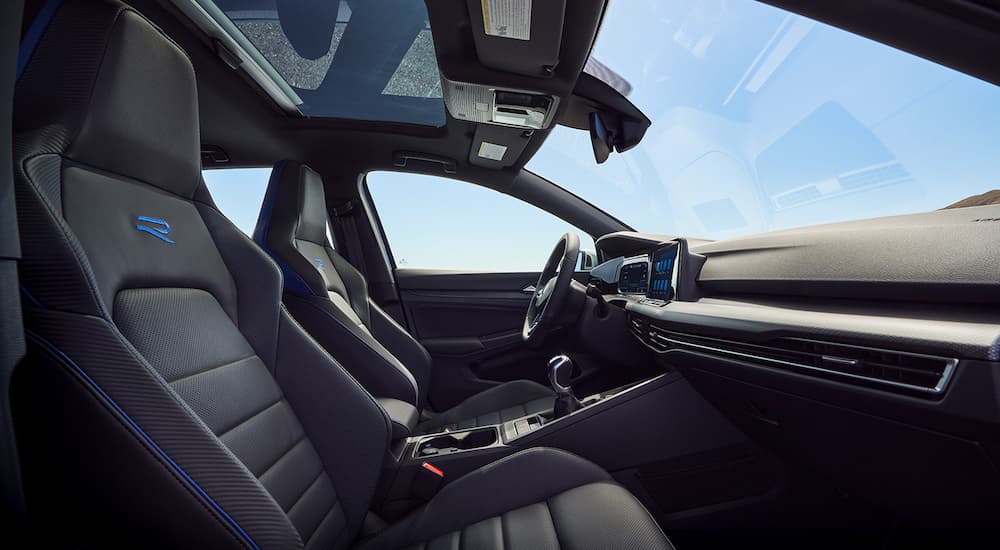 The interior of a 2022 VW Golf R is shown from the passenger door opening.