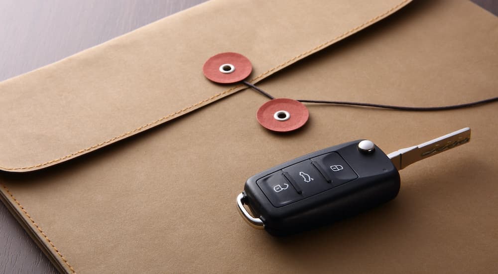 A car key is shown resting on top of an envelope.