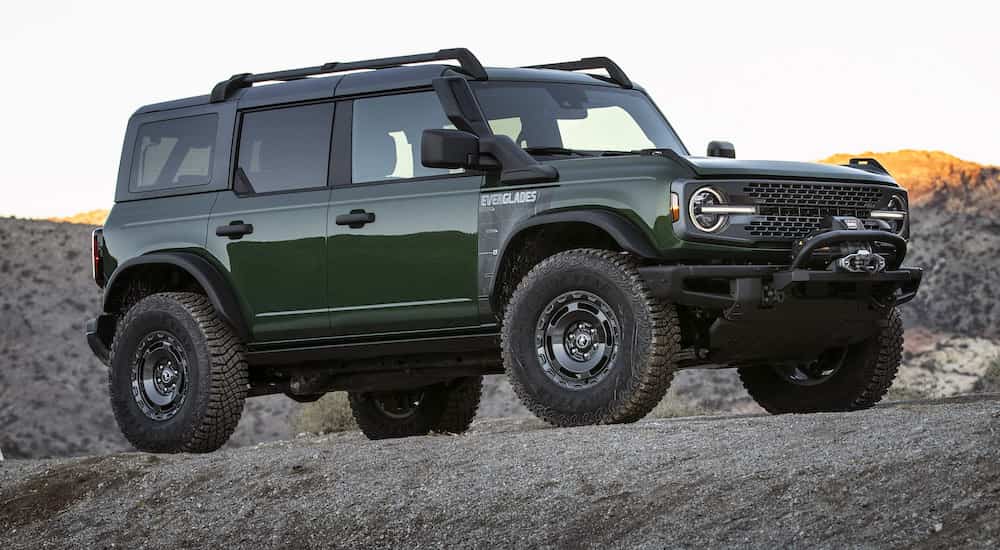 A green 2022 Ford Bronco Everglades, a popular Ford near you, is shown from the side while parked off-road.