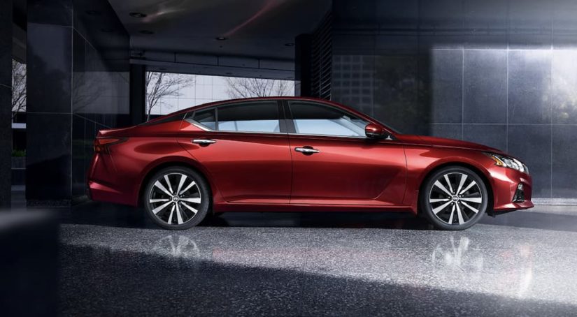 A red 2022 Nissan Altima is shown from the side during a 2022 Nissan Altima vs 2022 Honda Accord comparison.
