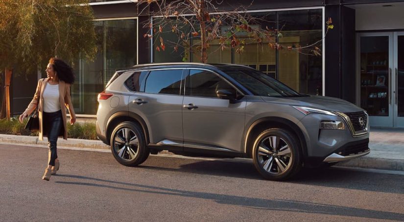 A grey 2022 Nissan Rogue is shown from the side on a city street.