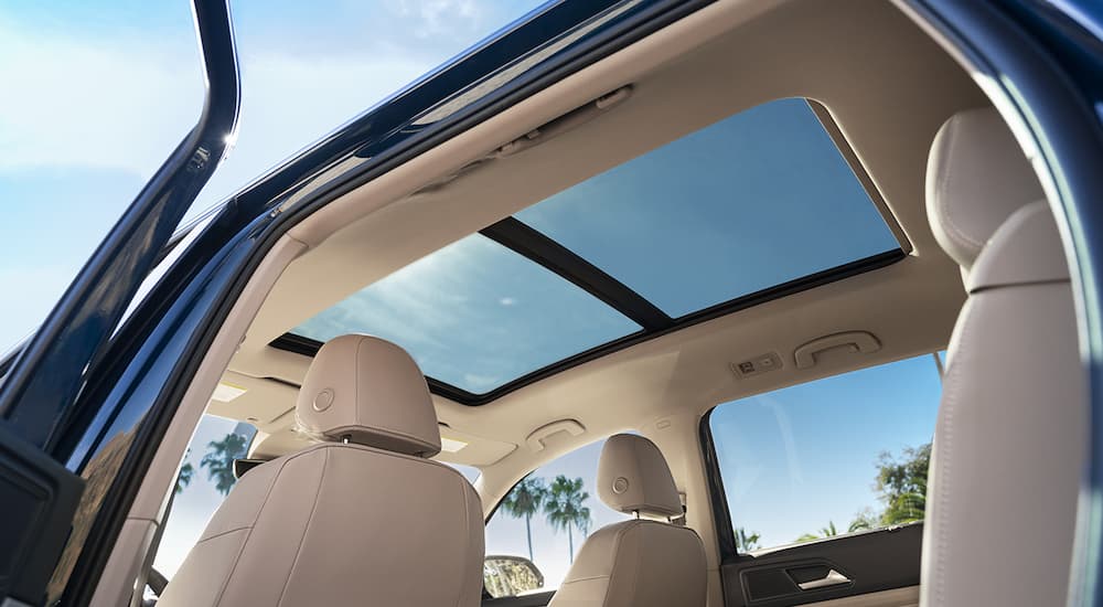 The interior and sunroof are shown in a blue 2022 Volkswagen Atlas.