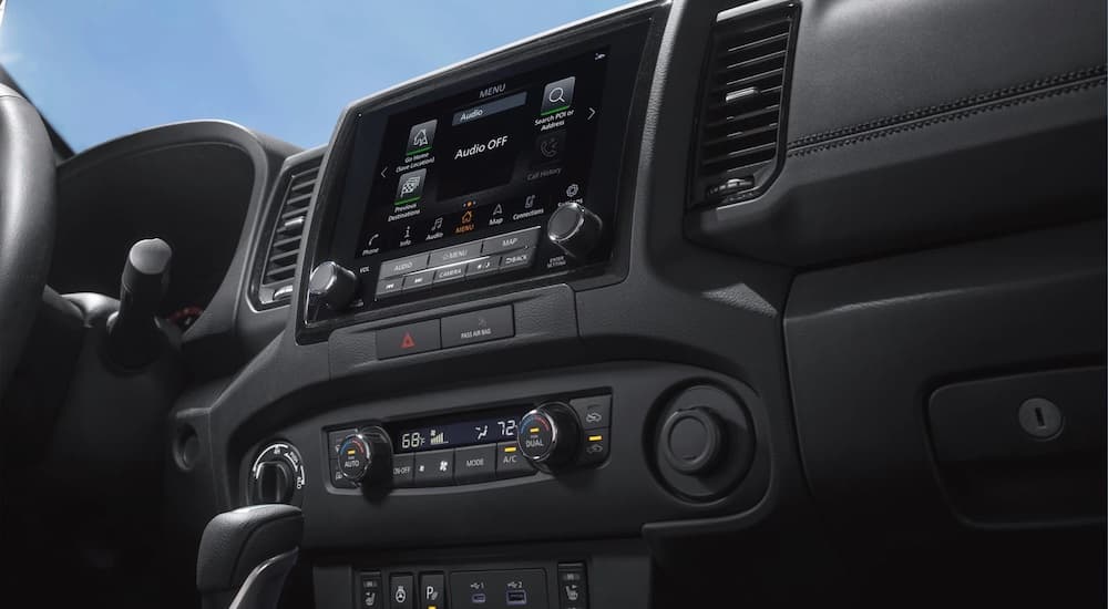 The interior of a 2022 Nissan Frontier is shown focusing on the infotainment system.