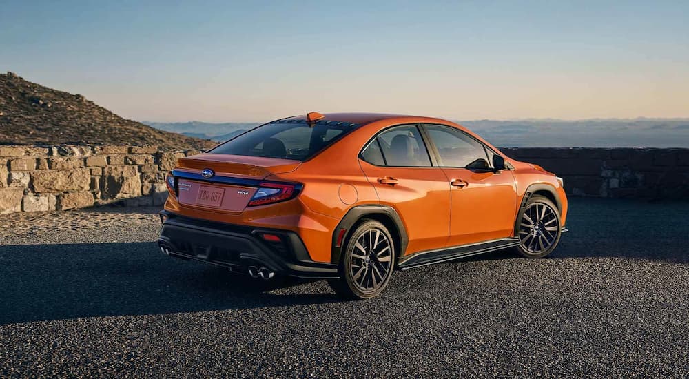 An orange 2022 Subaru WRX Limited is shown parked ay an overlook.