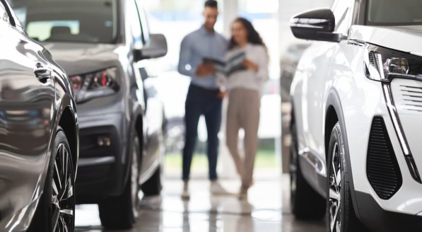 A couple is shown at a dealership looking at their car's trade in value.