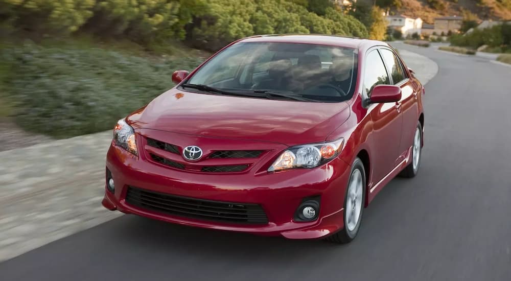 A red 2010 Toyota Corolla is shown driving on an open road.