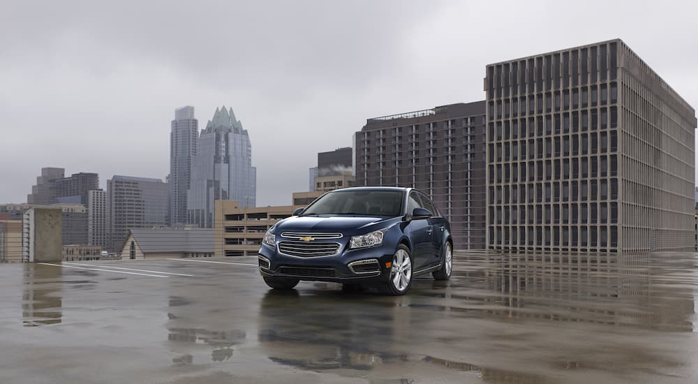 A dark blue 2015 Chevy Cruze LTZ is shown parked on a city rooftop.