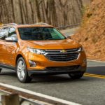 An orange 2018 Chevy Equinox is shown from the front after leaving a used Chevy Equinox dealer.