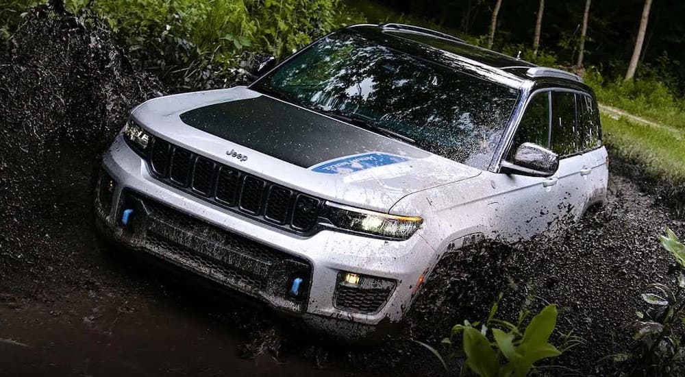 A white 2022 Jeep Grand Cherokee 4xe is shown from the front while off-road.