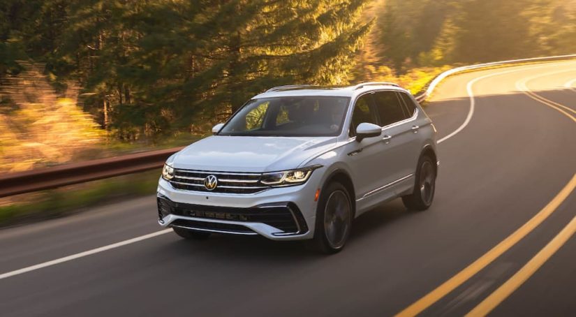 A white 2022 Volkswagen Tiguan SE is shown driving on an open road.