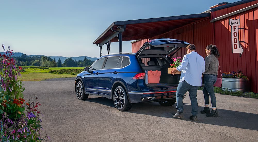 A blue 2022 Volkswagen Tiguan SE is shown with with an open trunk.