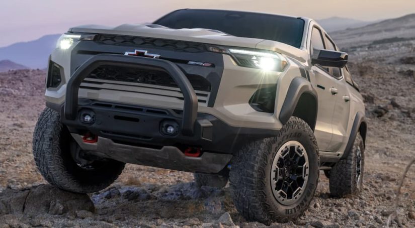 A tan 2023 Chevy Colorado ZR2 is shown from the front parked in a desert.