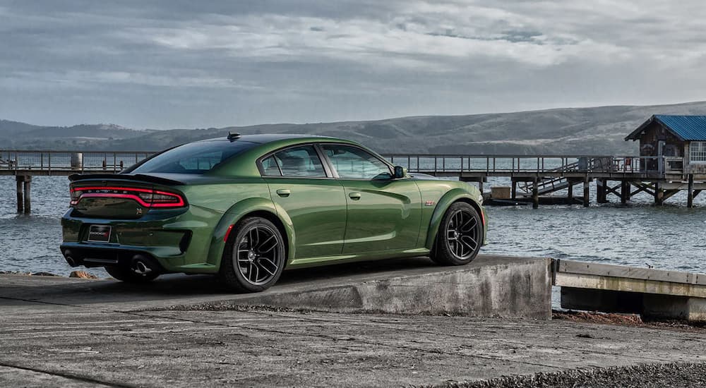 A green 2023 Dodge Charger Scat Pack is shown parked on a pier.