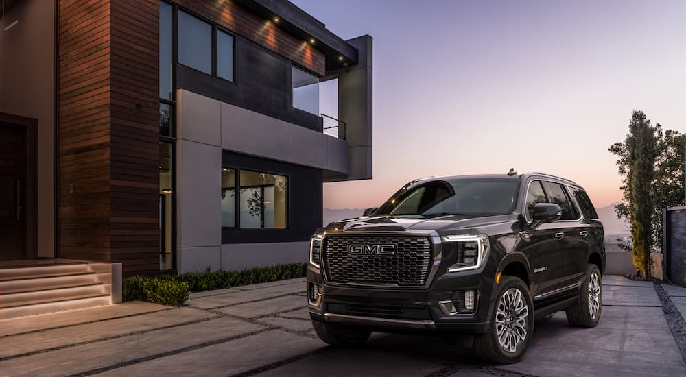A grey 2023 GMC Yukon Denali Ultimate is shown from the front at an angle while parked in a driveway.