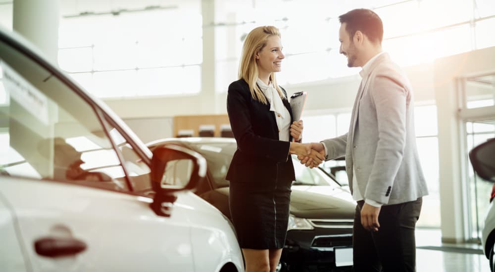 A customer is shown speaking to a saleswoman about car loans.