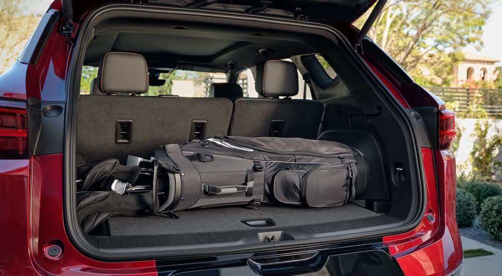 A set of golf clubs are shown in the trunk of a red 2023 Chevy Blazer RS.