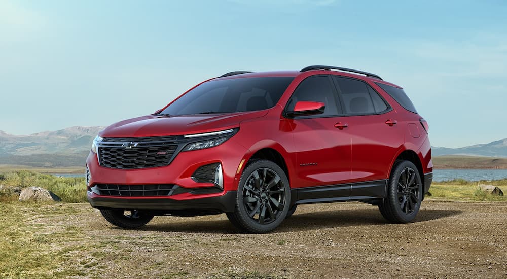 A red 2023 Chevy Equinox RS is shown parked in the mountains.