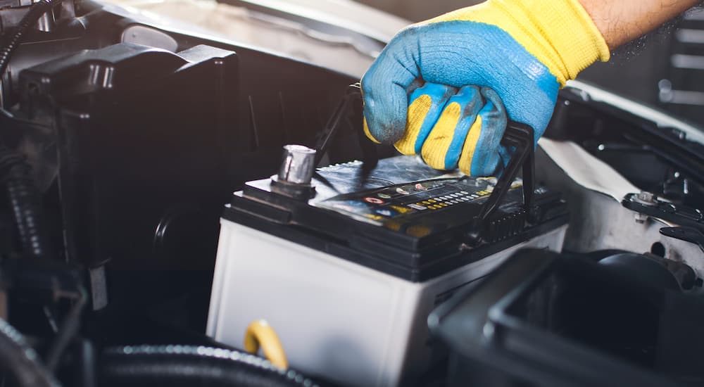 A person is shown changing out a car battery.