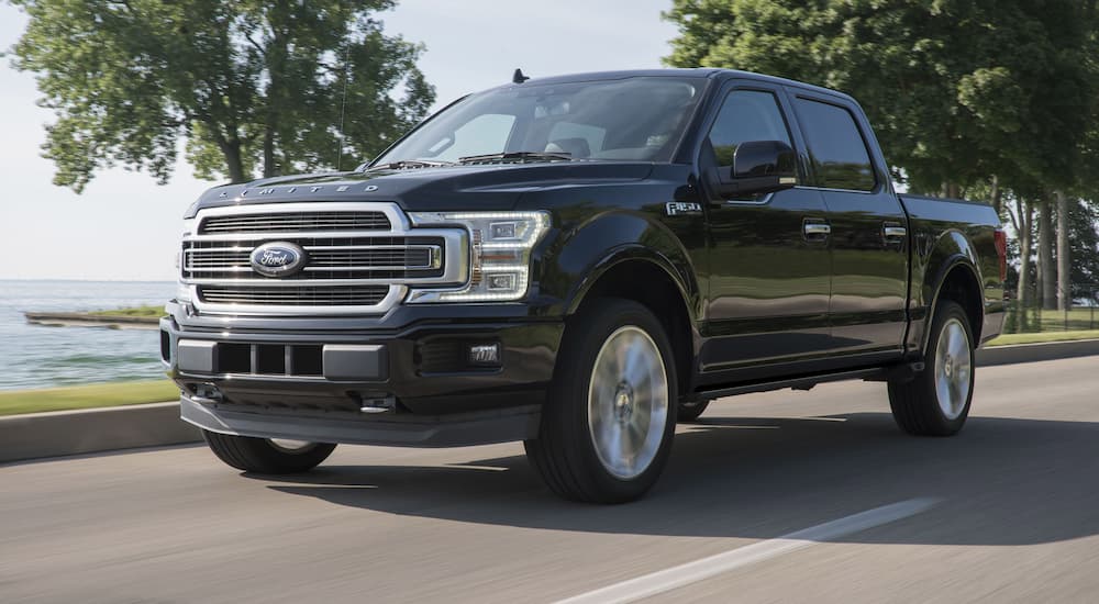 A black 2019 Ford F-150 is shown driving on an open road.
