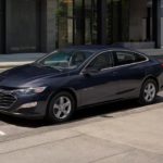 A black 2022 Chevy Malibu is shown parked on a city street.