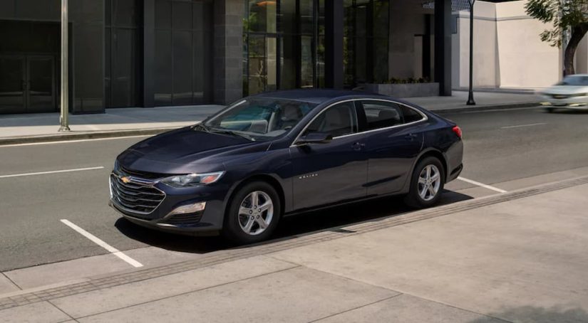 A black 2022 Chevy Malibu is shown parked on a city street.