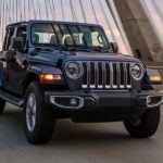 A grey 2022 Jeep Wrangler is shown from the front while crossing a bridge during a 2022 Jeep Wrangler vs 2022 Jeep Gladiator comparison.