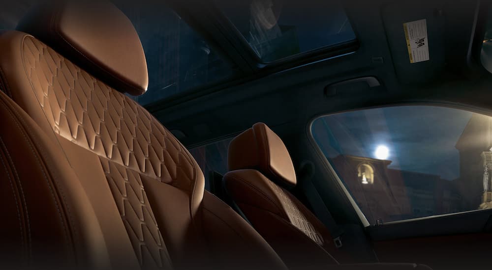 The brown interior of a 2023 BMW X5 shows the front seats.