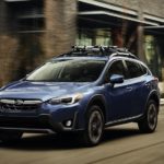 A blue 2020 Subaru Crosstrek is shown from the front at an angle on a city street.