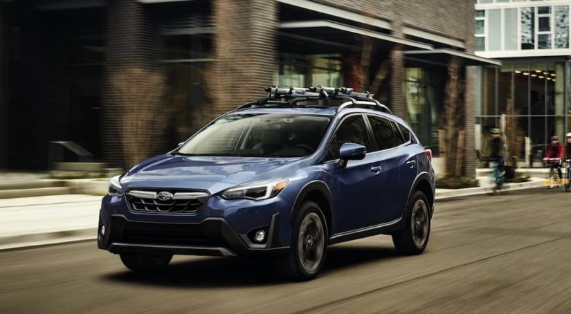 A blue 2020 Subaru Crosstrek is shown from the front at an angle on a city street.