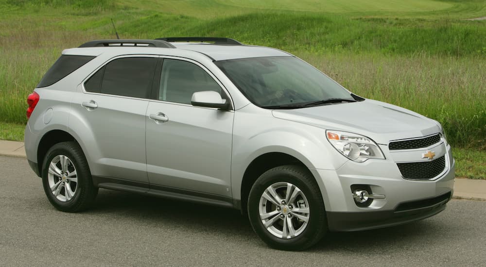 A tan 2009 Chevy Equinox is shown from the side parked in front of a grass hill.