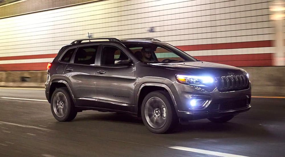 A popular Jeep Cherokee for Sale, a grey 2021 Jeep Cherokee Altitude, is shown driving through a tunnel.