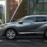 A grey 2022 Honda CR-V Hybrid is shown from the side on a city street.