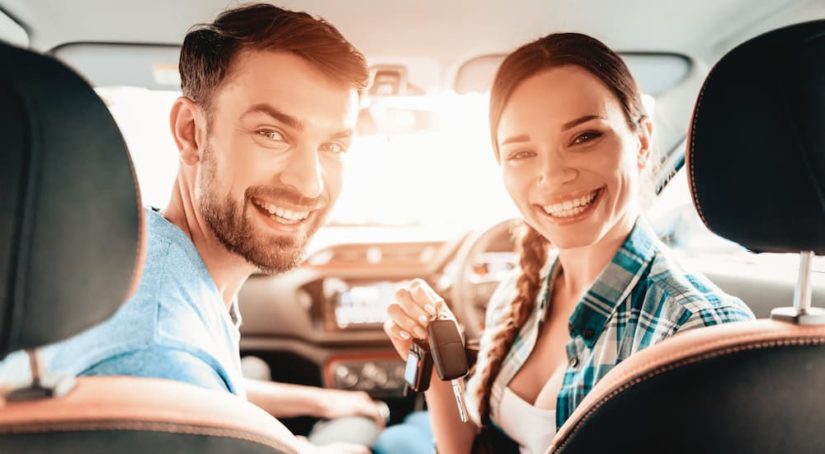 A couple is shown smiling before heading to a dealer to trade in their car.