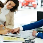 A couple is shown talking to a sales person about valuing their trade in.