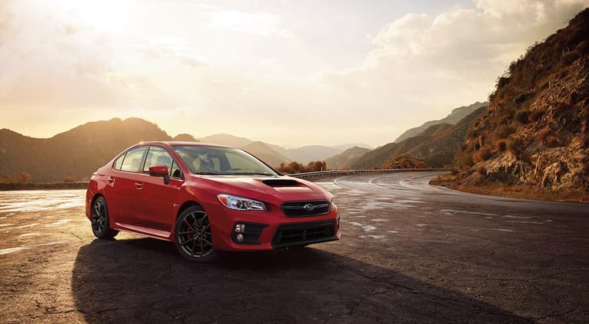 A red 2018 Subaru WRX is shown from the front at an angle after leaving a dealer that had used Subarus for sale.