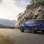 A blue 2023 Chevy Equinox Premier is shown from the rear at an angle.