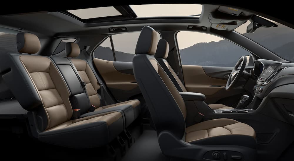 The brown and black interior of a 2023 Chevy Equinox shows two rows of seating.