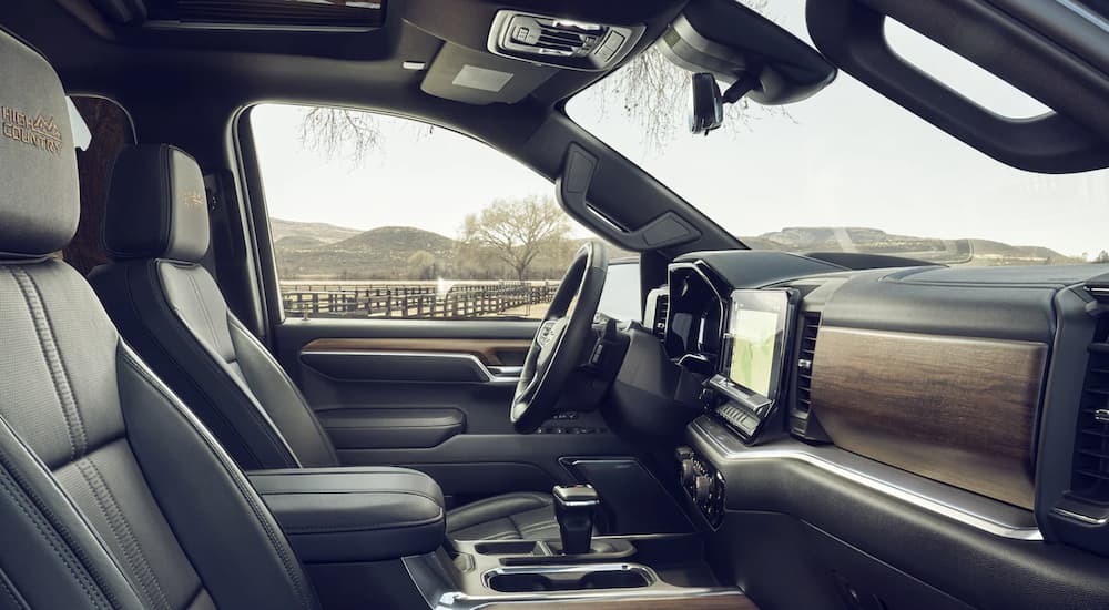 The grey interior of a 2023 Chevy Silverado 1500 shows the steering wheel.