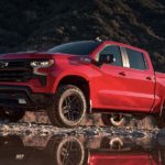 A red 2023 Chevy Silverado 1500 Z71 is shown from the side off-roading.