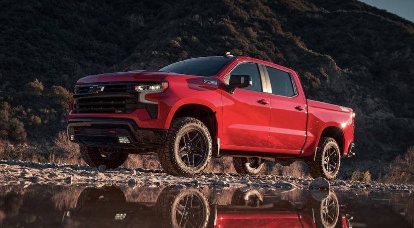 A red 2023 Chevy Silverado 1500 is shown from the side off-roading.