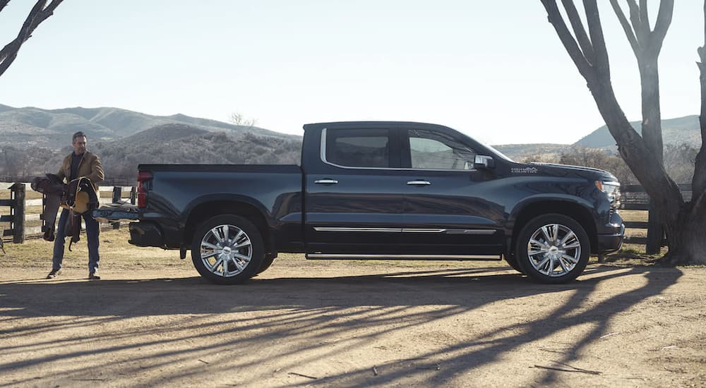 A blue 2023 Chevy Silverado 1500 High Country is shown from the side during a 2023 Chevy Silverado 1500 vs 2023 Toyota Tundra comparison.