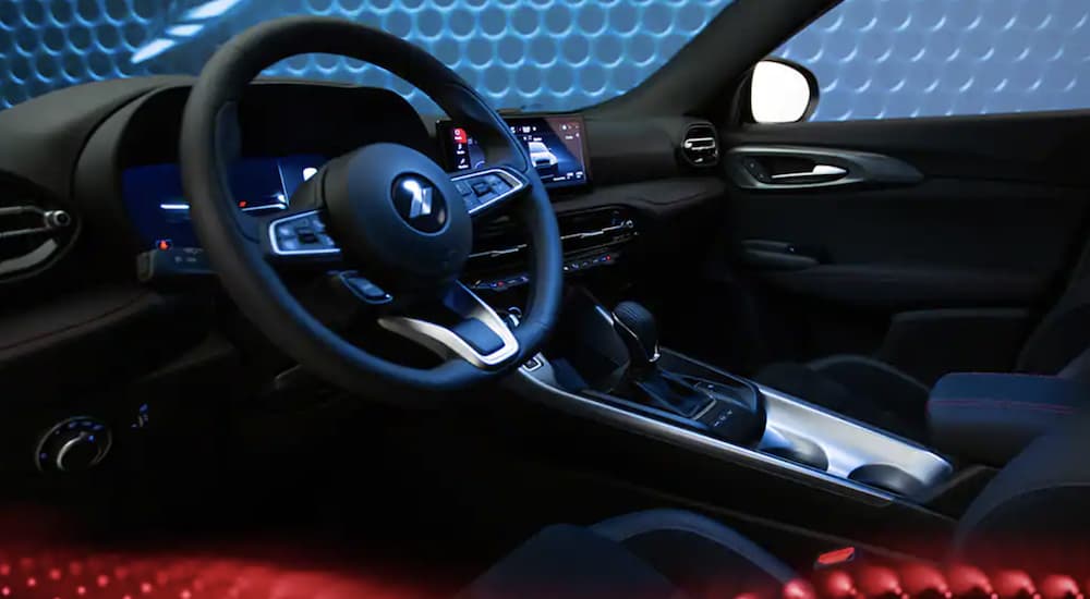 The black interior of a 2023 Dodge Hornet shows the steering wheel.