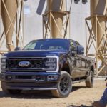 A blue 2023 Ford F-250 STX is shown parked at a construction site.