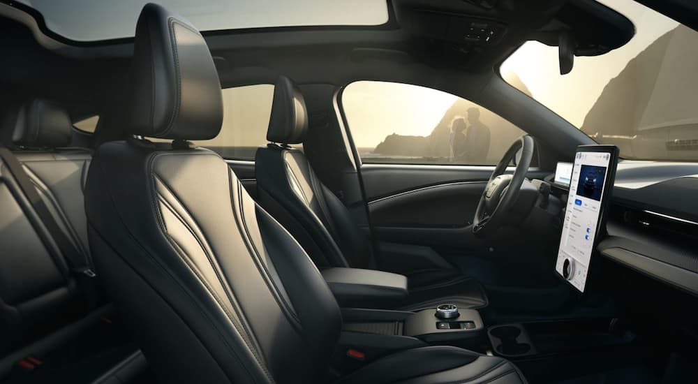 The black interior of a 2023 Ford Mustang Mach-E shows the front seats.