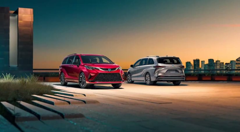 A red and a silver 2023 Toyota Sienna XSE are shown parked at sunset.