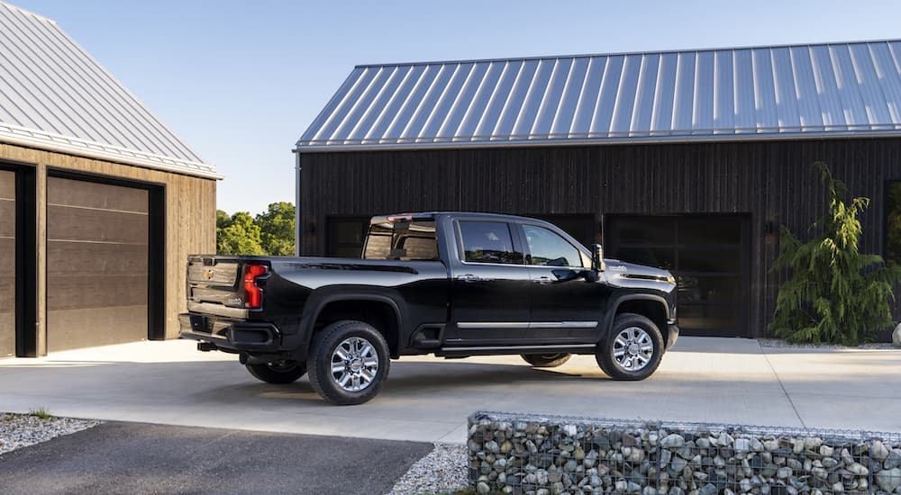A black 2023 Chevy Silverado 2500HD is shown from the rear at an angle.