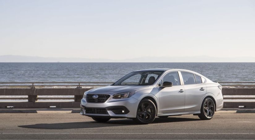 A silver 2023 Subaru Legacy Sport is shown from the front at an angle on a coast.