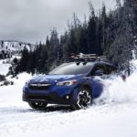 A blue 2023 Subaru Crosstrek is shown from the front in the snow.