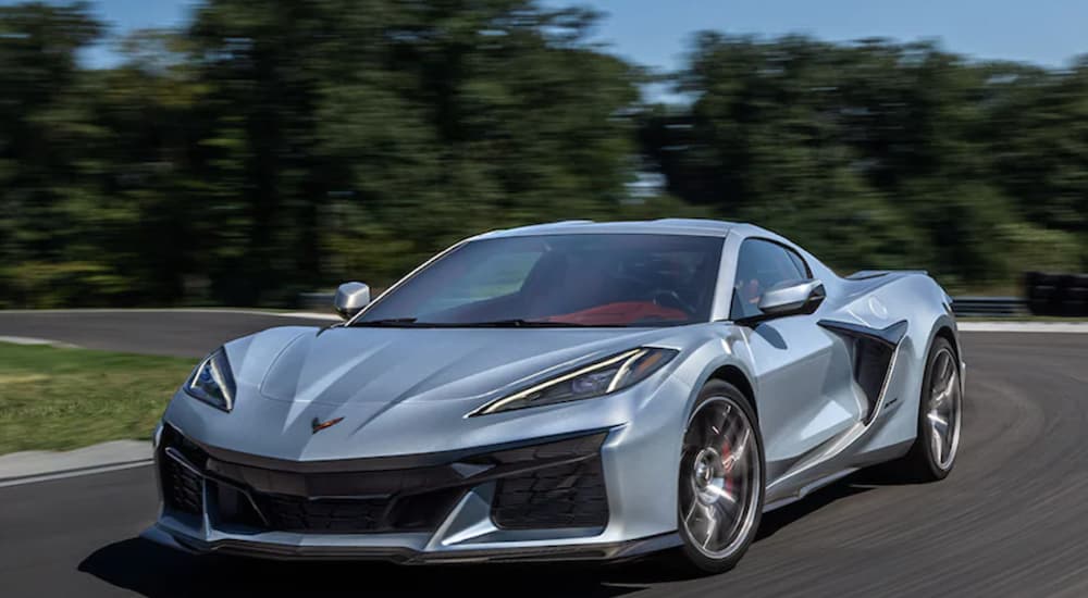 A silver 2023 Corvette Z06 is shown driving on an open track.